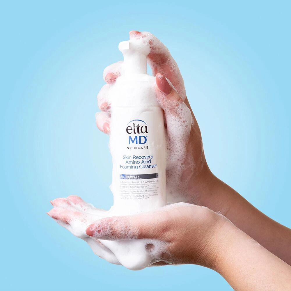 a person's hands holding a bottle of foam