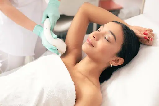 a woman lying down and having Arms Laser Hair Removal in Costa Mesa, CA